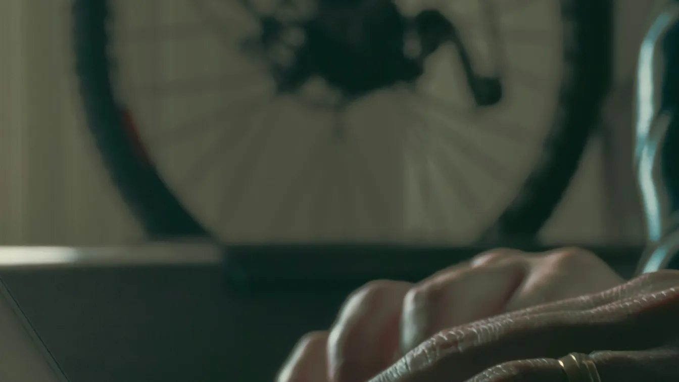 a woman typing on a laptop with a bicycle in the background