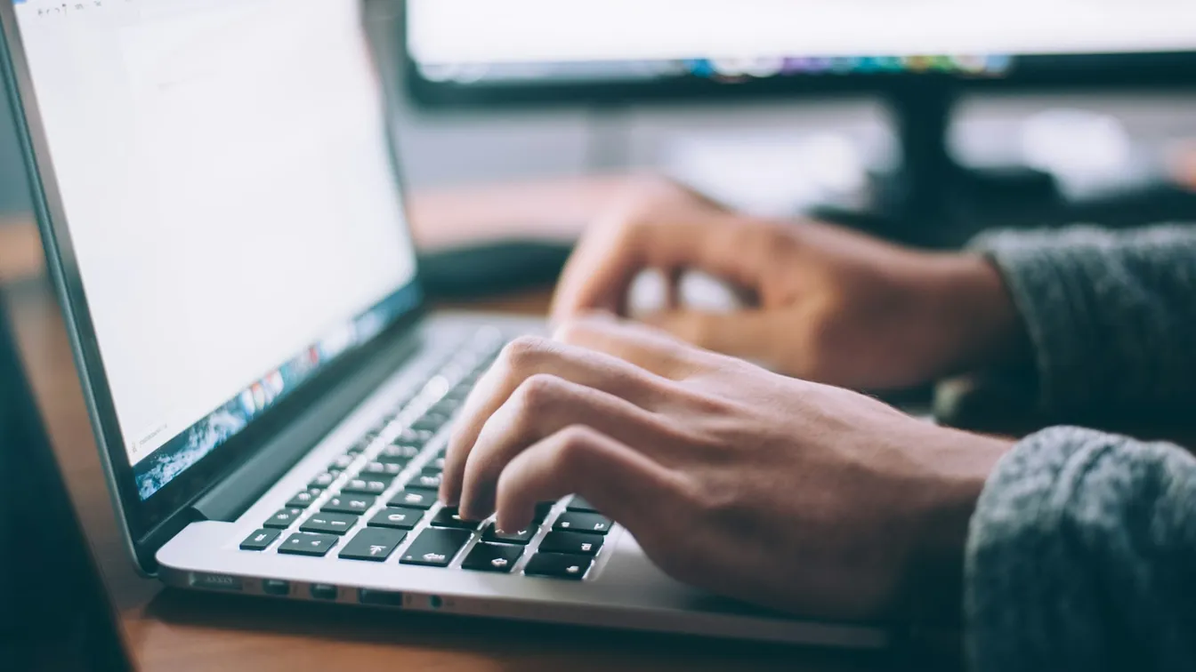 a person typing on a laptop computer