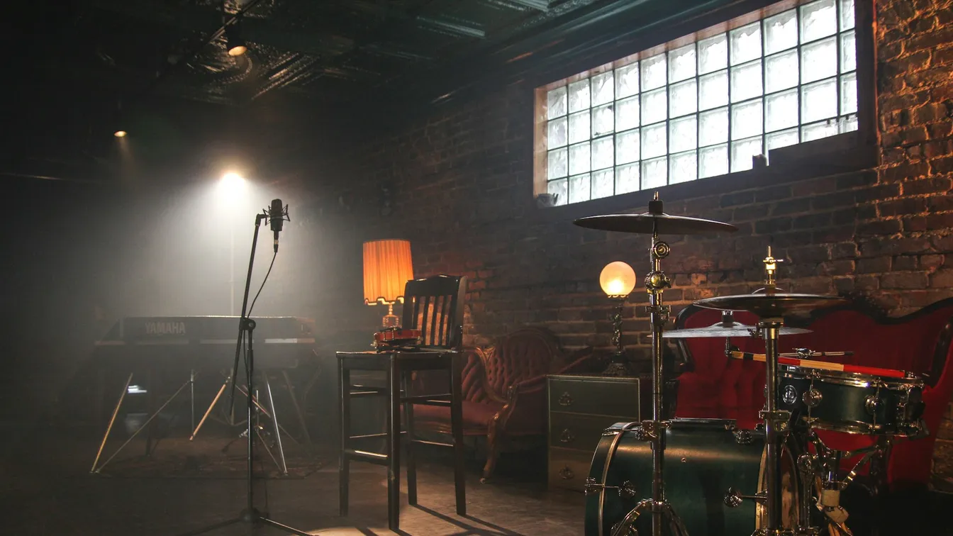 a room with a drum set and a microphone