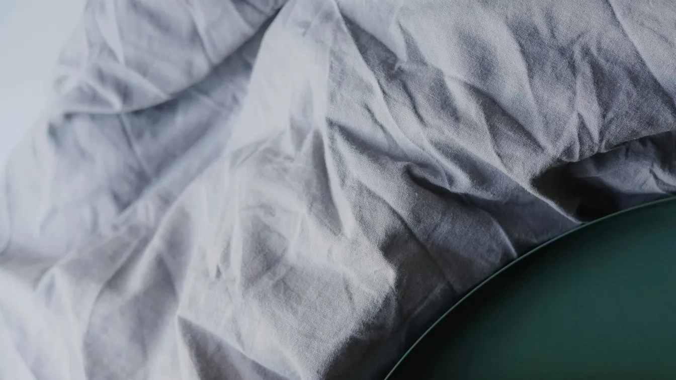 a close up of a bed with sheets on it